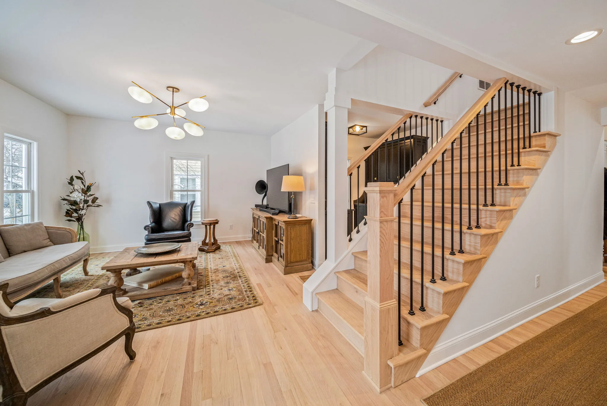 Open living room with iron staircase railing — whole-home renovation