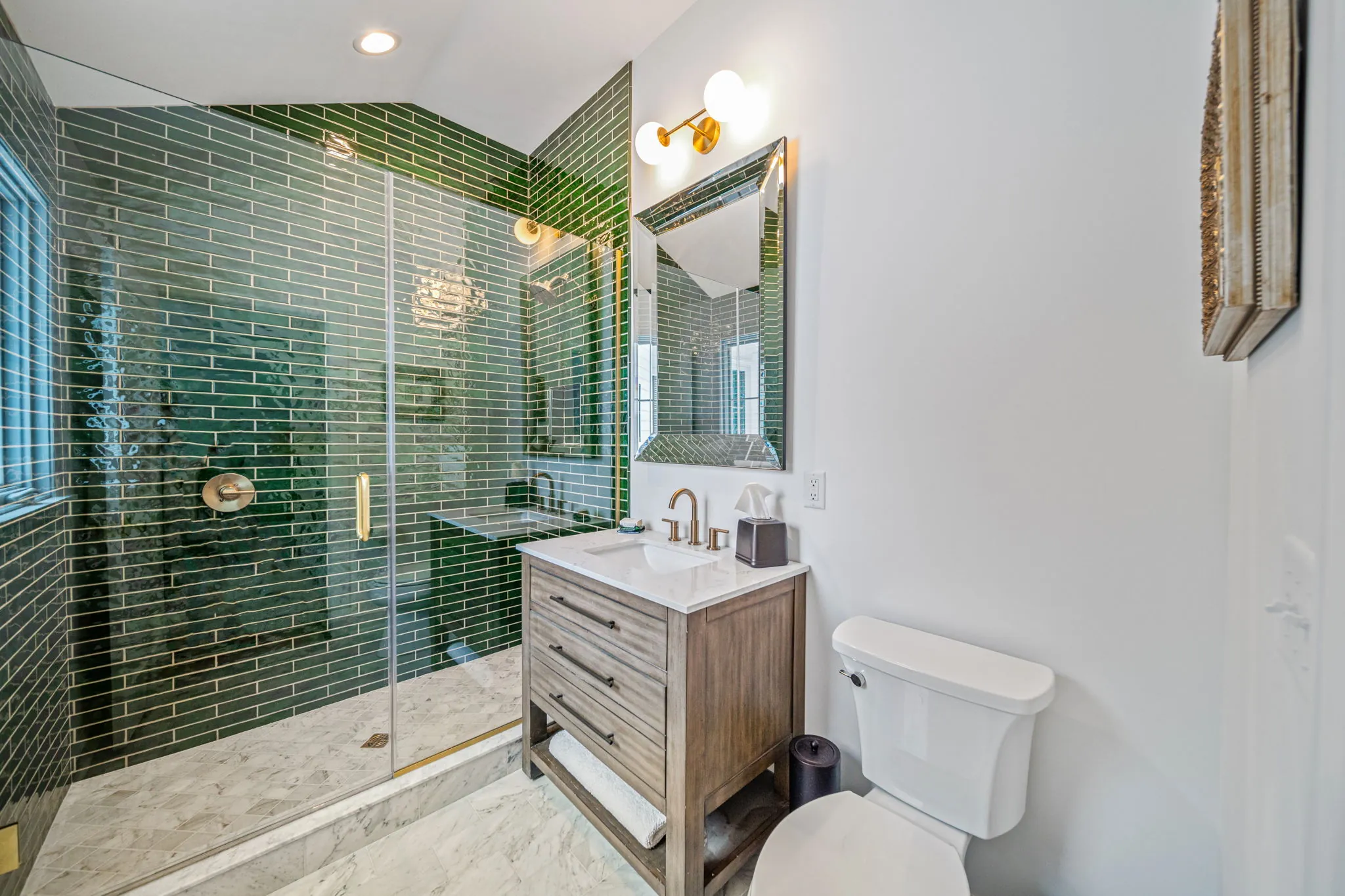 Green subway tile shower with brass fixtures — bathroom remodel