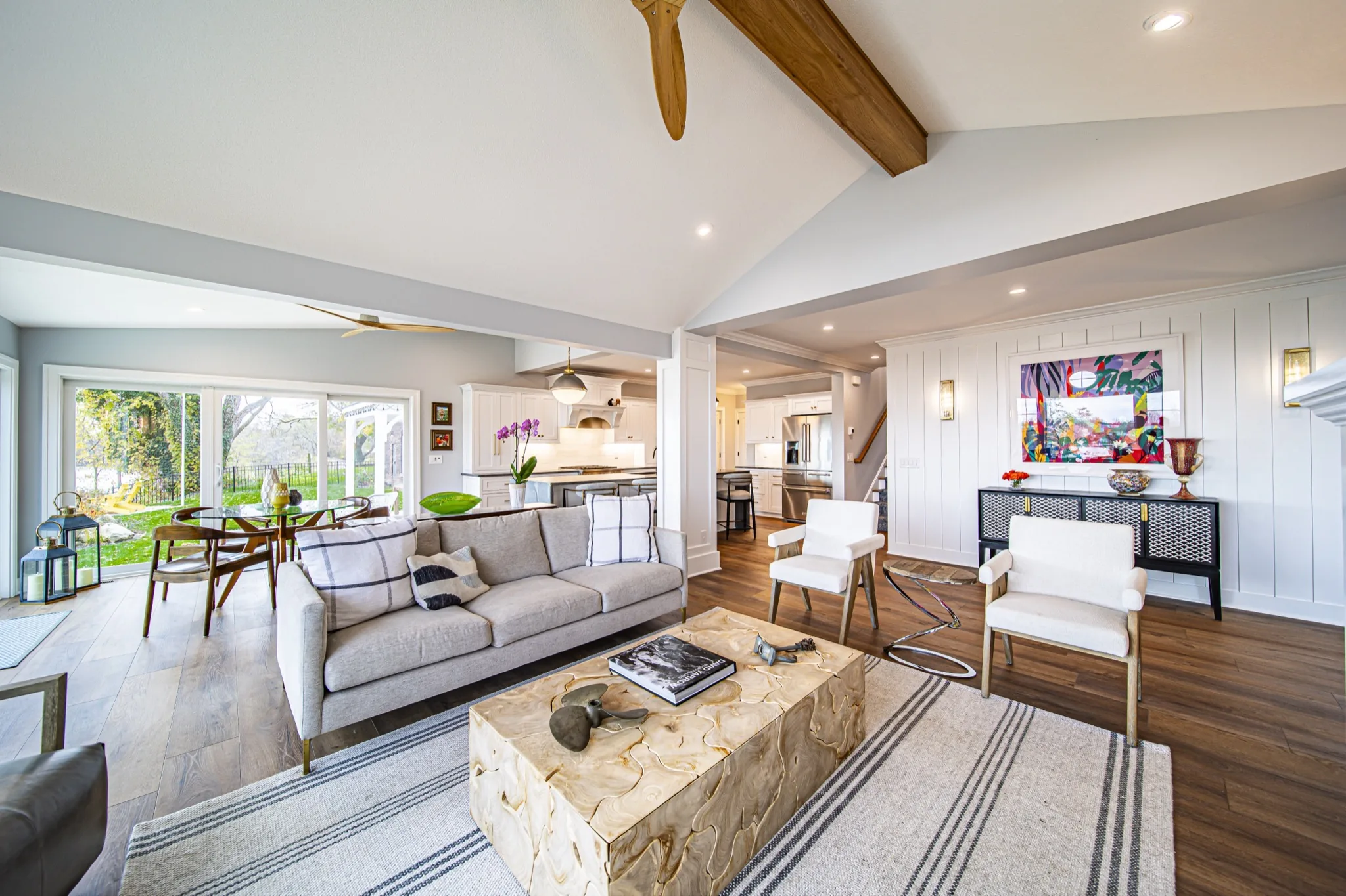 Vaulted open-concept living room with exposed beam flowing into craftsman kitchen — custom floor plan by Skoda Construction, Northeast Ohio