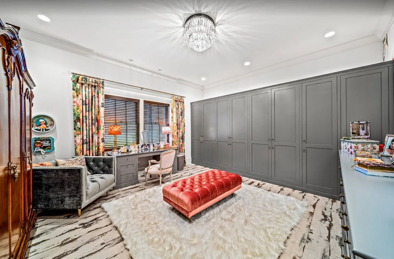 Luxury dressing room with floor-to-ceiling dark gray wardrobe cabinets, crystal flush-mount light, tufted ottoman, and marble floor — custom estate by Skoda Construction, Northeast Ohio